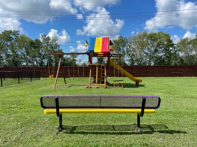 Playground with swings and slide at Angleton RV Park & Resort
